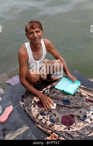 India Rajasthan, Udaipur uomo di mezza età il lavaggio a mano sui passi del Lago Pichola Foto Stock