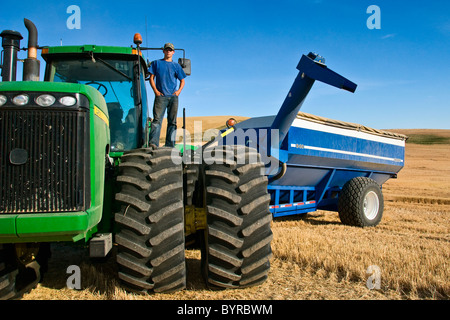 Un giovane agricoltore in cima il suo trattore durante una breve pausa da raccolto nella regione di Palouse / vicino al Pullman, Washington, Stati Uniti d'America. Foto Stock