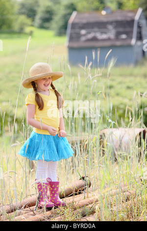 Una ragazza che indossa un cappello di paglia e stivali di gomma su una fattoria; troutdale, Oregon, Stati Uniti d'America Foto Stock