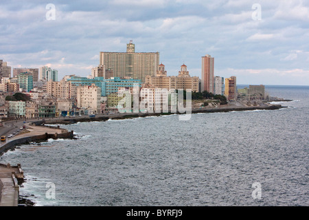 L'Avana, Cuba. Il Malecon, il lungomare affacciato sul Mar dei Caraibi. Hotel Nacional dietro gli alberi, Edificio Focsa più indietro. Foto Stock