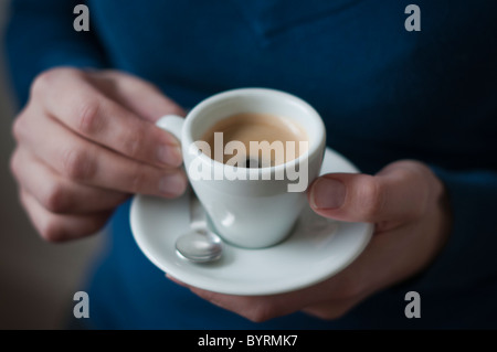 Close-up di una donna con un espresso nelle sue mani Foto Stock