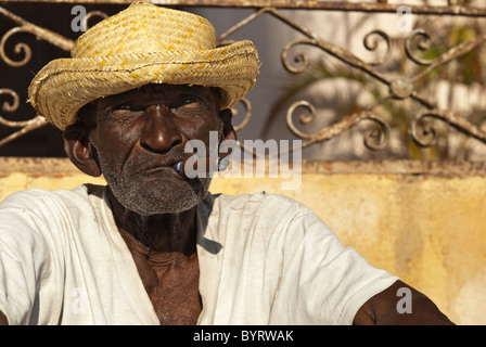 Uomo vecchio con un sigaro seduti in strada, Trinidad, Sancti Spiritus, Cuba, Caraibi Foto Stock