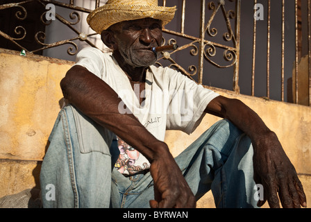 Uomo vecchio con un sigaro seduti in strada, Trinidad, Sancti Spiritus, Cuba, Caraibi Foto Stock