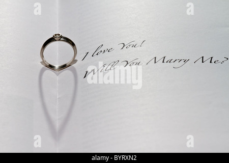 Anello cuore di colata ombra nel libro con la frase "ti amo! Ti sposerà me?". Foto Stock