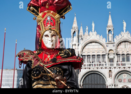 Uomo veneziano in costume nero con una maschera dorata Foto stock