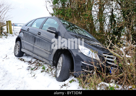 Auto nel fosso. Una vettura si è schiantato nella siepe sulla curva di un ghiacciate, innevate road. Foto Stock