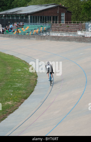 Un ciclista passeggiate intorno al velodromo via a Herne Hill nel sud di Londra. Foto Stock