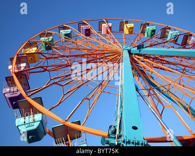 Una ruota panoramica con cabine colorate a livello locale fiera del divertimento Foto Stock