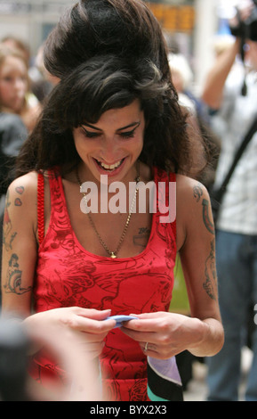 Amy Winehouse facendo gli ultimi ritocchi per i suoi capelli prima di salire su un treno alla stazione di Paddington con il marito, Foto Stock