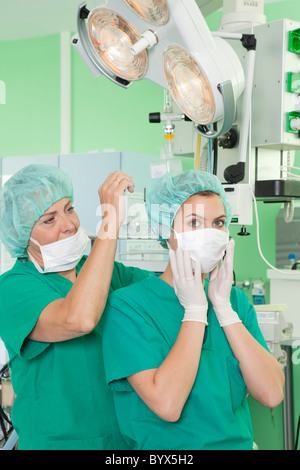 Gli infermieri in scrubs aiutando con maschera Foto Stock