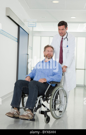 Medico con il paziente in sedia a rotelle Foto Stock