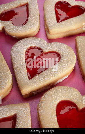 Vicino la fotografia di un cuore di biscotto a forma di rosa su sfondo, biscotto in corrispondenza di un angolo, biscotti in background Foto Stock