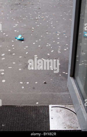 Scartata la gomma da masticare e gigatettes sul terreno al di fuori dell'ingresso di un edificio pubblico. Foto Stock