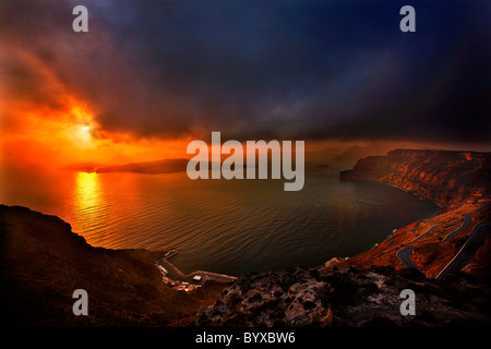 Tramonto a Santorini, giusto al di sopra del porto di Athinios, in vista di una grande parte della caldera in cattive condizioni atmosferiche. La Grecia Foto Stock