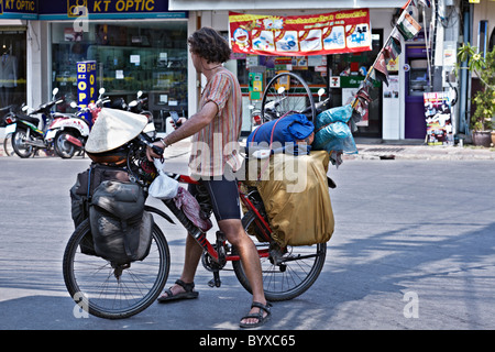 A lunga distanza in bicicletta. Un maschio ciclista a viaggiare per il globo arriva in Thailandia con il suo completamente caricato in bicicletta e bandiere raffiguranti del Paese visitato Foto Stock