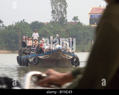 Il Vietnam il caricamento di scooter e biciclette di una chiatta per attraversare il fiume a Hoi An Foto © Julio Etchart Foto Stock