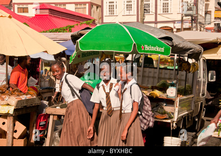 Scuola ragazze in uniforme a produrre stand nel centro di St Georges, Grenada, Caraibi orientali Foto Stock