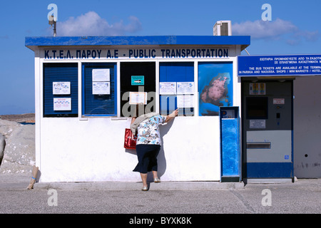 Donna greca di comprare un biglietto a Parikia la stazione degli autobus, sul Cyclade isola di Paros. Foto Stock