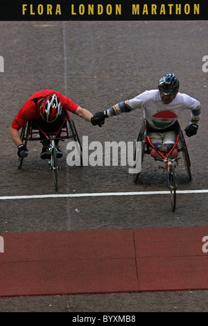 Sedia a rotelle atleti attraversare la linea del 2009 Flora London Marathon Foto Stock