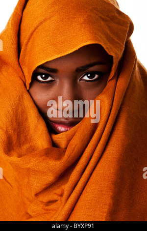 Bella misteriosa nomade africano volto femminile in terra ocra testa tono wrap sciarpa cercando. Foto Stock