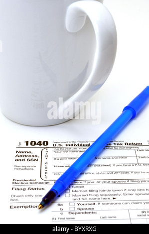 Imposta di IRS Form 1040 con penna a inchiostro e tazza di caffè isolato su sfondo bianco. Foto Stock