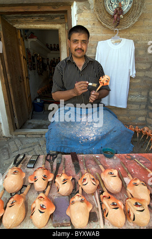 Puppet maker pittura le teste dei burattini, Khiva, Uzbekistan Foto Stock