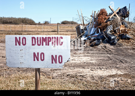 Cartello 'no dump', cestino accatastato. Foto Stock