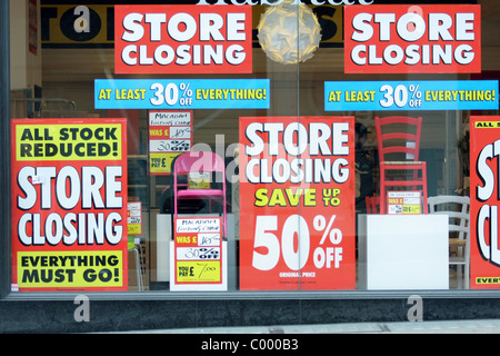 Chiusura e vendita segni in una vetrina di un negozio Foto Stock