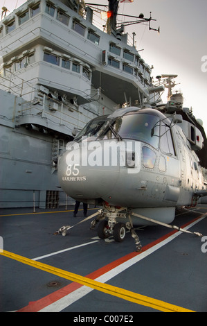 Un elicottero Merlin sul per'd sollevare circa per la discesa alla staffa del British portaerei HMS Ark Royal Foto Stock