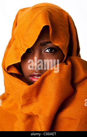 Bella misteriosa africana beduini nomadi volto femminile in terra ocra testa tono wrap sciarpa cercando. Foto Stock