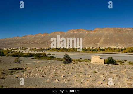 Il cimitero di berbera in terra arida lungo il fiume Ziz a ponte per Ait Khoujmani Marocco sotto il cielo blu Foto Stock