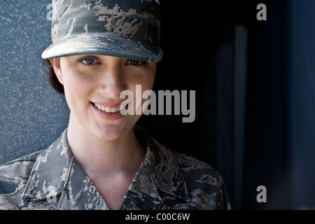 Sorridente giovane donna in ARMY COMBAT UNIFORM Foto Stock