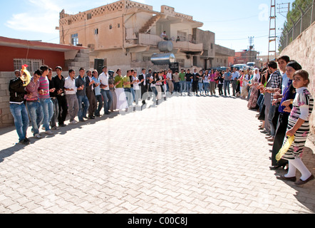 Lingua curda uomini e donne tenendo le mani durante un matrimonio tradizionale danza del cerchio nella città di Mardin, in Anatolia sudorientale regione della Turchia. Foto Stock