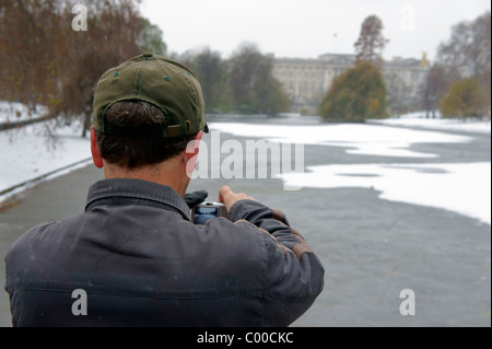 Un uomo di scattare una foto di Buckingham Palace a Londra Foto Stock