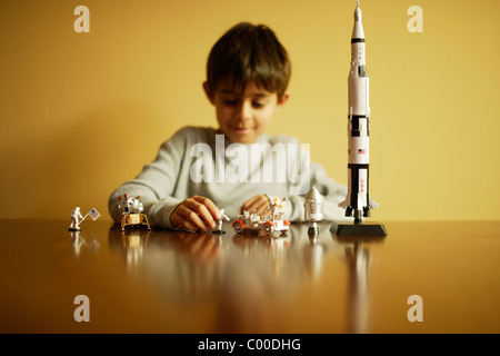 Ragazzo con il modello di Saturno V Apollo moon rocket, astronauti, modulo lunare e Rover lunari. Foto Stock