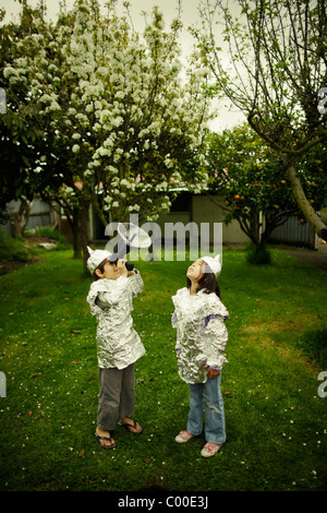 I bambini indossare la lamina di cottura pur guardando fuori per una possibile invasione aliena. Foto Stock