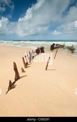 Relitto sulla spiaggia australiana durante il giorno (alterate beach, Queensland) con interessanti la formazione di nube in background Foto Stock