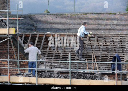 Costruttori di riparazione sul tetto di casa old England Regno Unito Foto Stock