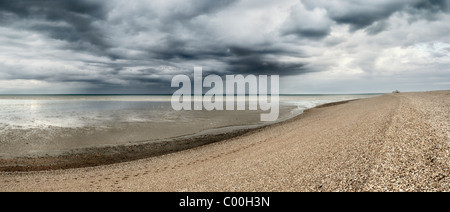 Spiaggia di ciottoli a dungeness piccola barca da pesca può essere visto sulla spiaggia di ciottoli nella distanza di Dungeness kent england Foto Stock