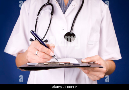 Professionista sanitario, medico o infermiere, scrivere con una penna stilografica su un foglio di carta su una cartella. Foto Stock