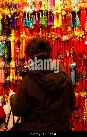 Donna shopping per buona fortuna fascino al Capodanno cinese nella International Village Mall, Chinatown, Vancouver, BC, Canada Foto Stock