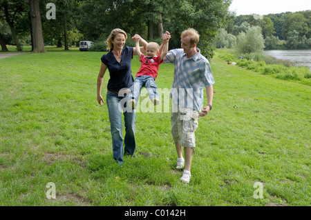 Coppia giovane giocando con un bambino, ragazzo, 4 anni Foto Stock