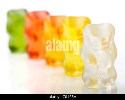 Gummy bears candy in una fila su un fondo bianco... DOF poco profondo. Foto Stock