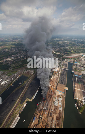 Vista aerea, fumo, fuoco su un isola di scarto nella Duisport porto interno, Duisburg, Ruhrgebiet regione Renania settentrionale-Vestfalia Foto Stock