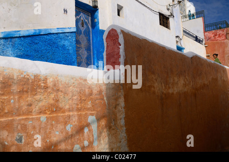 Giovane donna che guarda verso il basso a partire da una ocra rossa nel muro della città blu di Oudaia Kasbah Marocco Rabat Foto Stock