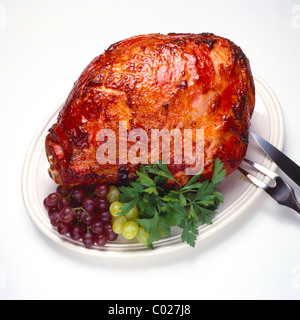 Prosciutto affumicato sul piatto da portata con uve e prezzemolo e guarnire Foto Stock