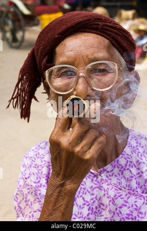 Vecchia donna fumatori cheroot a Bagan, Myanmar Foto Stock