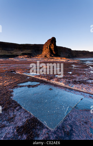 Bassa sun all'alba Saltwick Bay nel North Yorkshire. Foto Stock