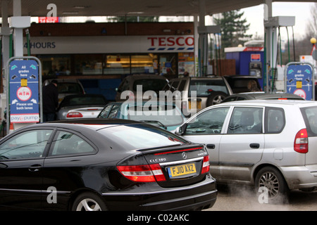 La gente di riempimento automobili fino alla stazione di benzina Foto Stock