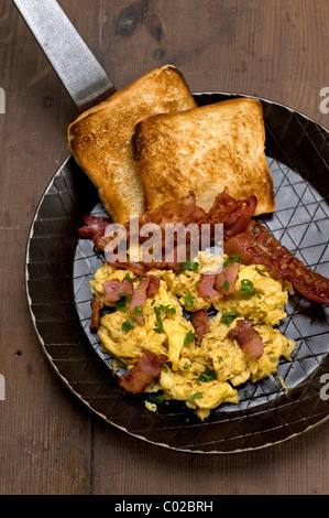 Uova strapazzate con pancetta fritta e toast Foto Stock